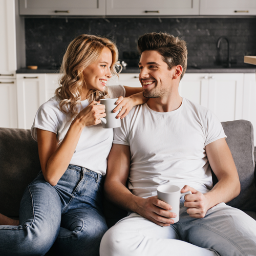 A happy young couple holding coffee mugs inside one of our Atlanta Short Term Rentals.